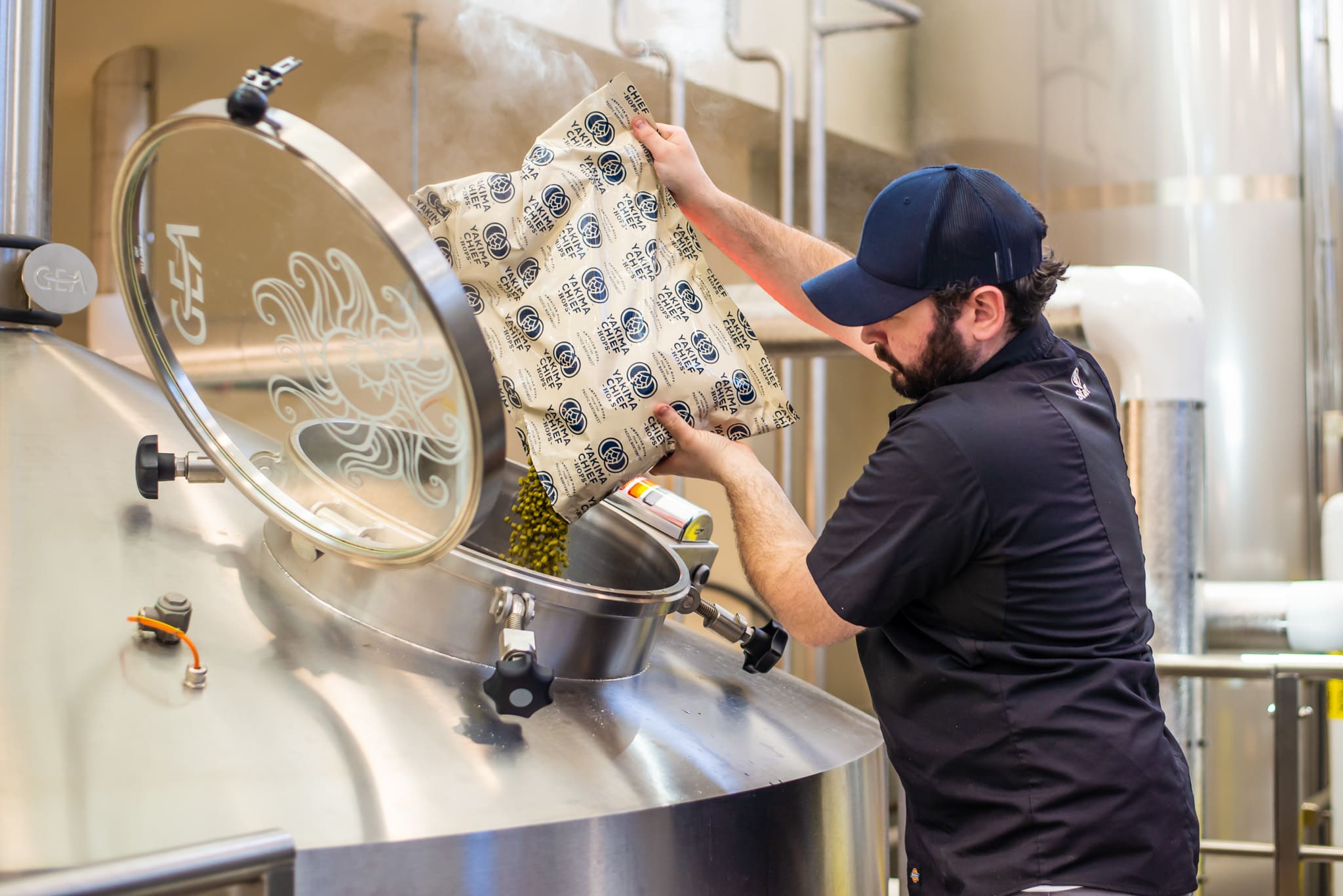 Worker dumping hops into equipment